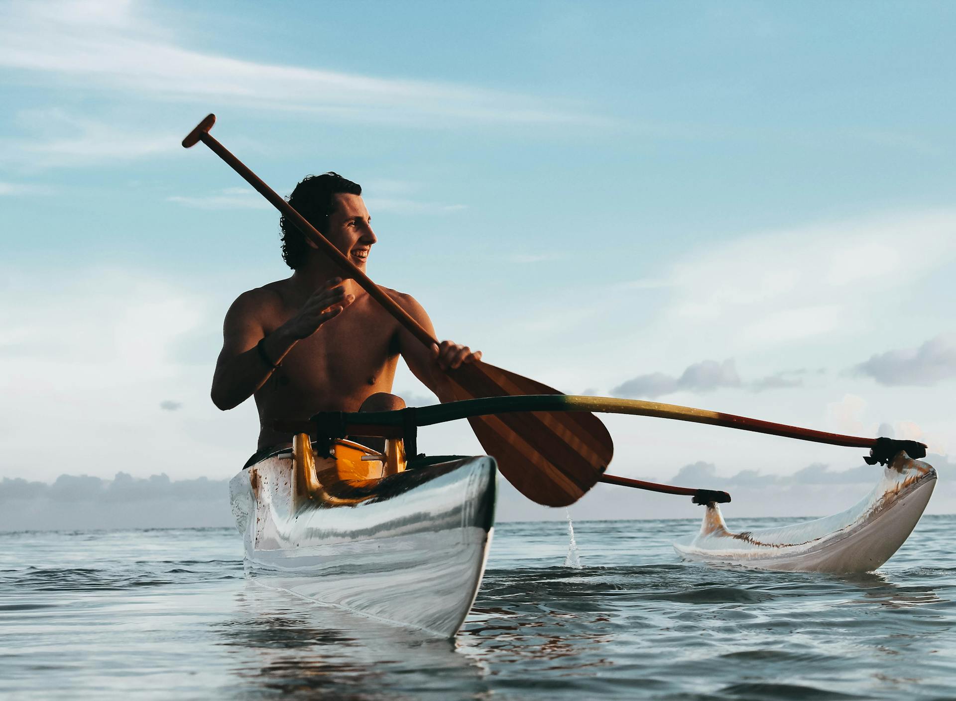 Man holding a paddle while riding a kayak in the sea