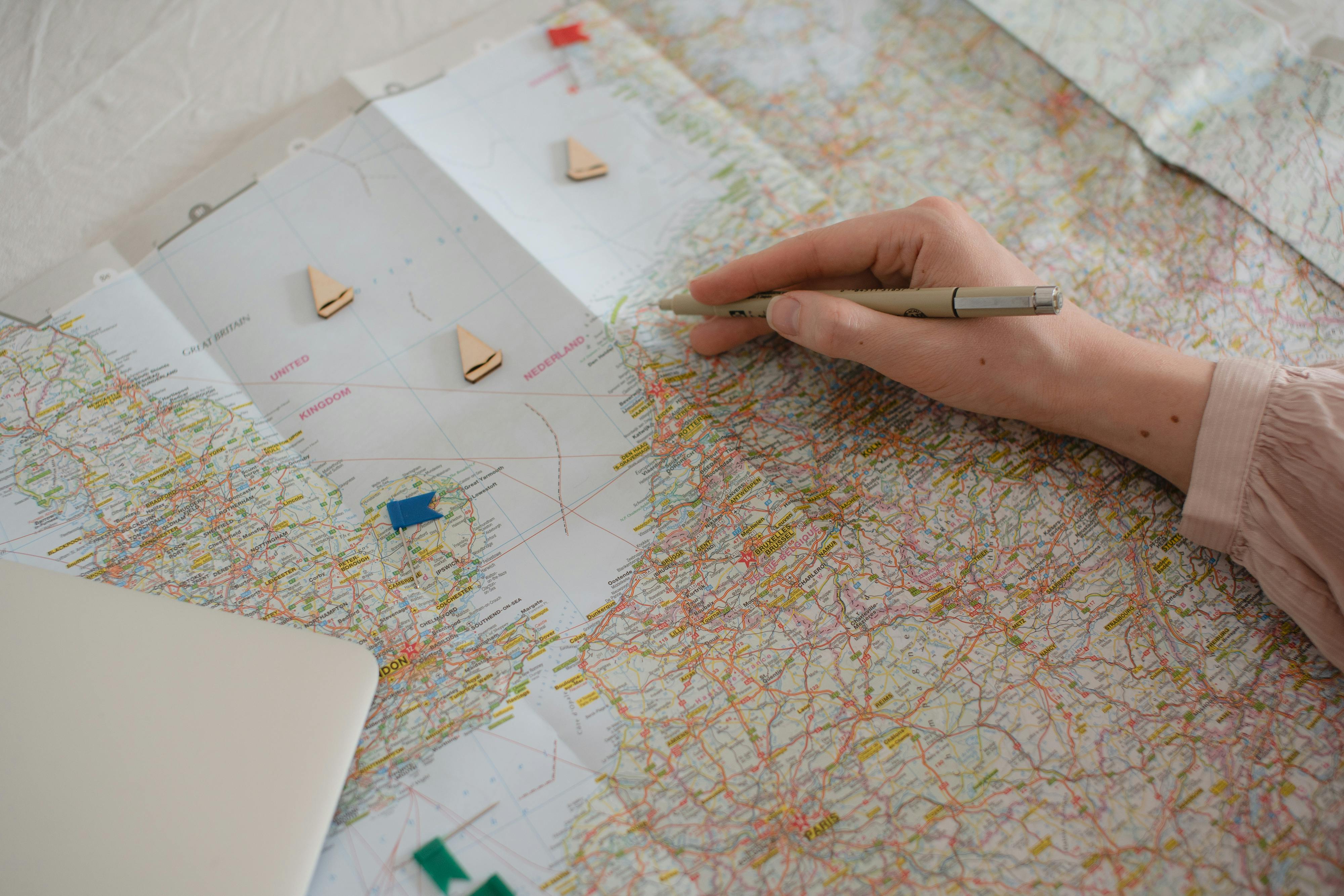 A person holding a pen over a map